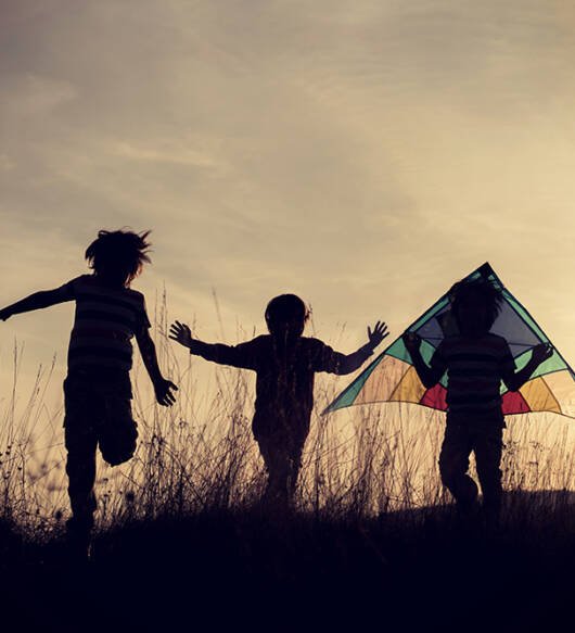 Group of kids enjoying their time on the meadow during sunset