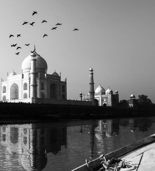 Taj Mahal reflected in Yamuna River view from wooden boat in bla