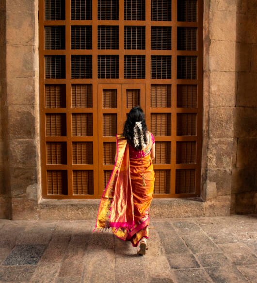 rear-view-woman-walking-street-against-temple-door