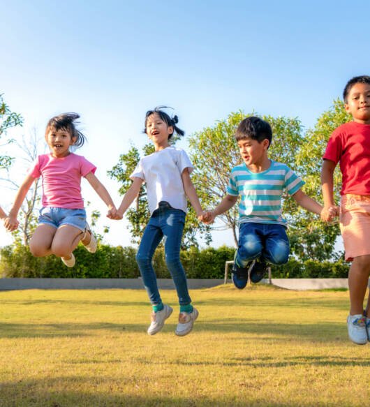 Large group of happy Asian smiling kindergarten kids friends hol