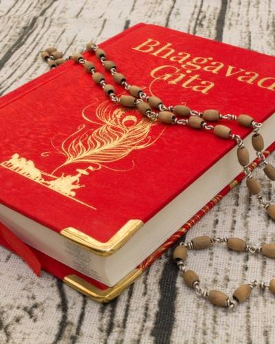 Maski,Karnataka,India – DECEMBER 29,2018 : Holy Bhagavad gita with wooden textured bckground. Maski,Karnataka,India - DECEMBER 29,2018 : Holy Bhagavad gita with wooden textured bckground