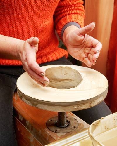 Hands forming clay pot Female hands forming clay pot on the pottery wheel