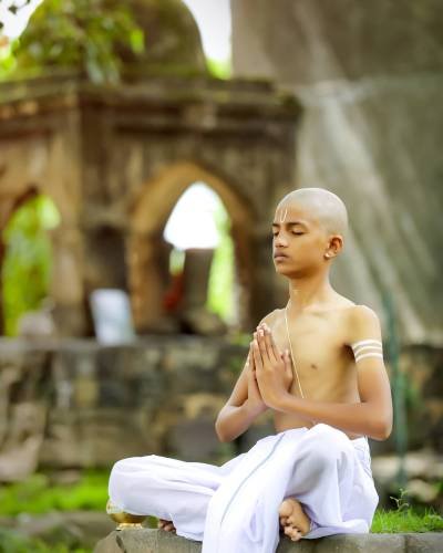 indian priest child doing yoga at park