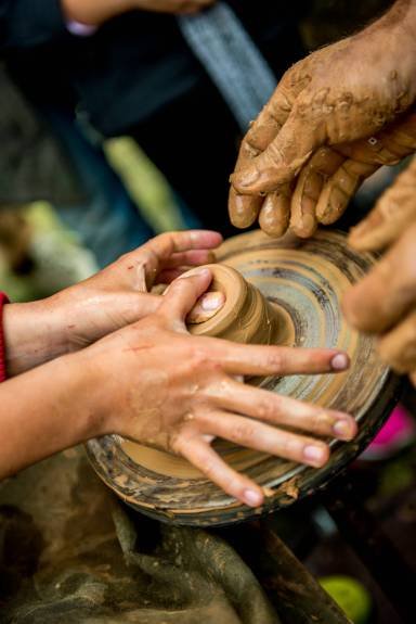 work with clay the teacher helps his student to work with clay. Work on the potter's wheel.